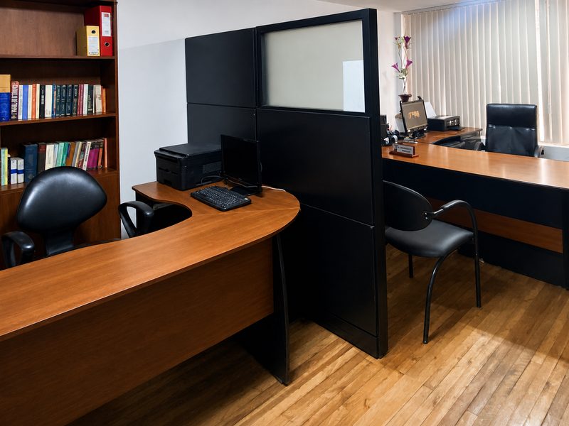 Área de trabajo del estudio, con la biblioteca jurídica al fondo
